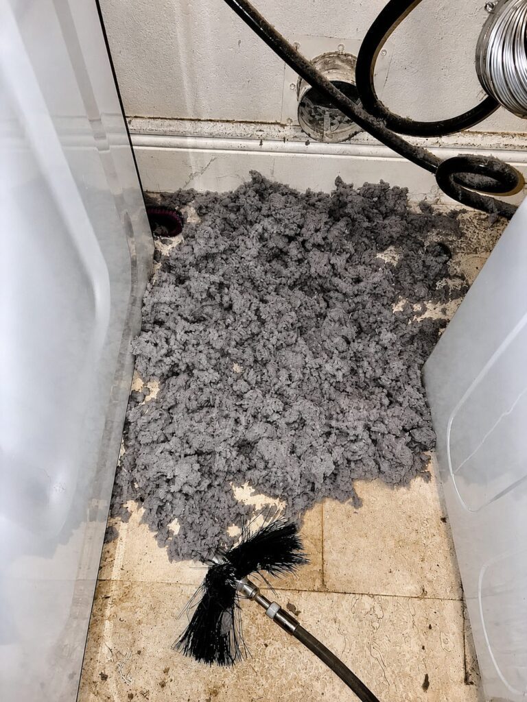 Lint buildup piled behind a dryer in a Round Rock home before vent cleaning