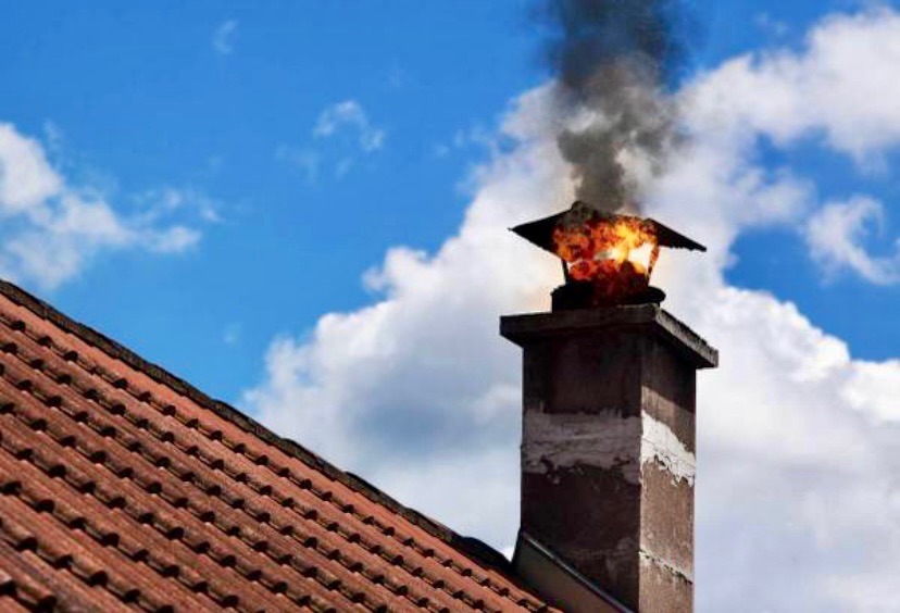 Chimney fire being safely cleaned during chimney sweep service