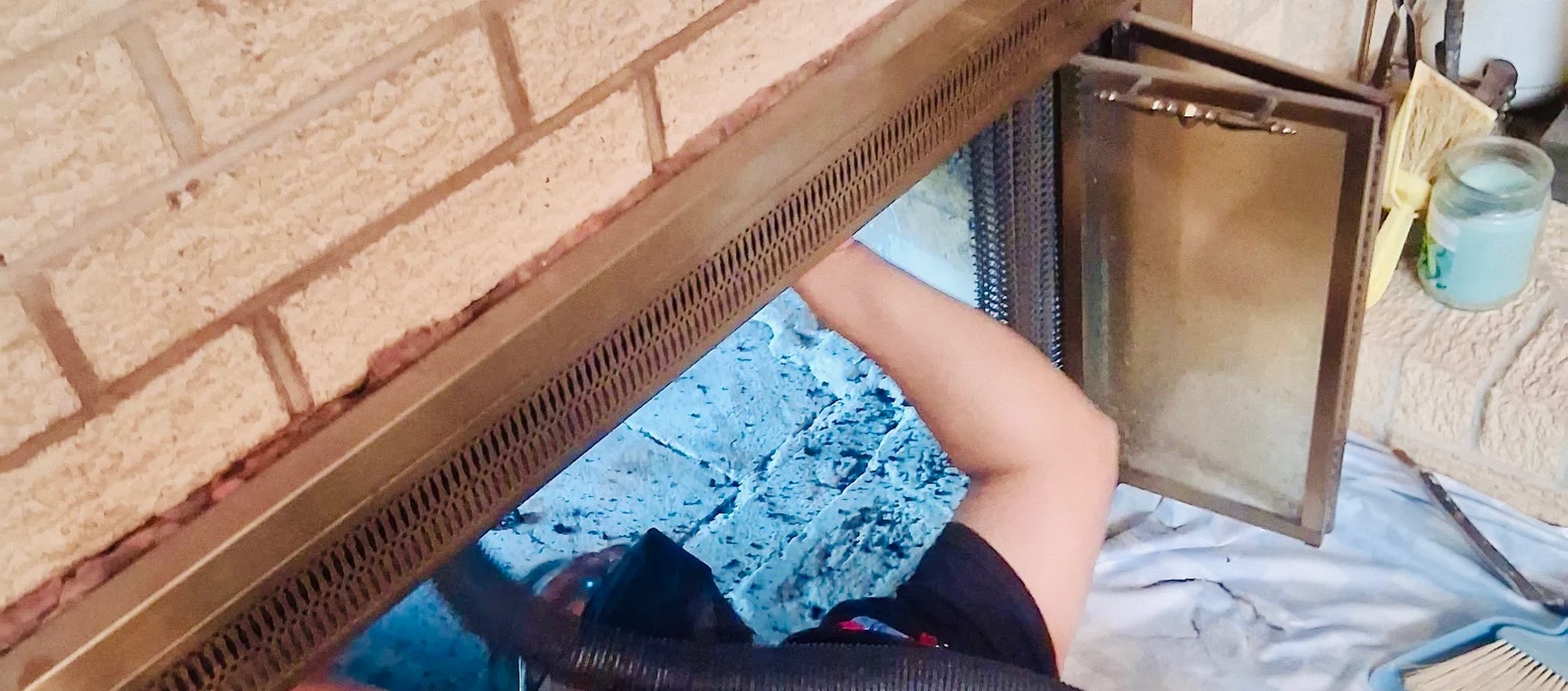 Chimney being swept and vacuumed at the firebox with the opening covered