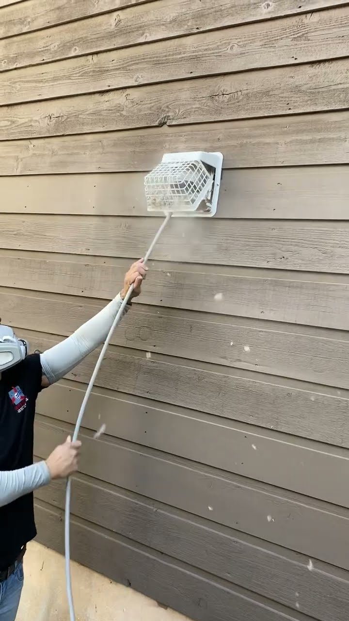 Lint blasting out of a dryer vent during a cleaning at a Cedar Park home