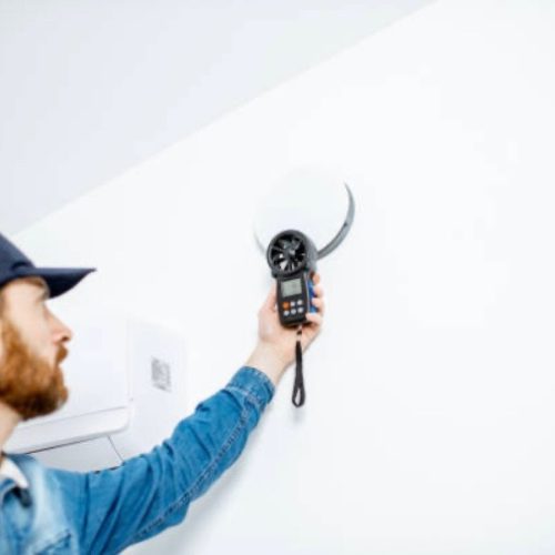 Technician performing indoor air quality testing with monitoring device